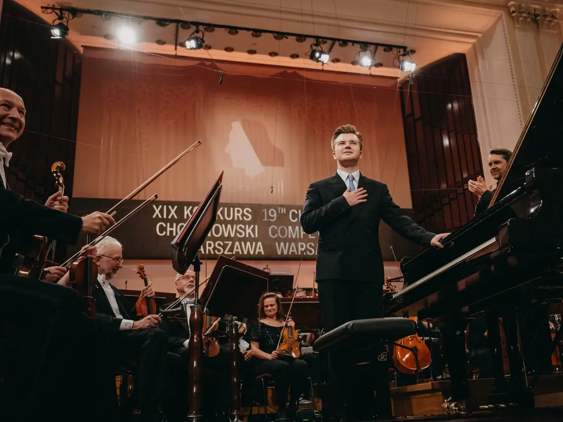 Piotr Alexewicz na estradzie. Uśmiecha się z wdzięcznością.