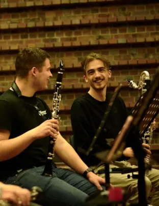 Na zdjęciu widać dw&oacute;ch mężczyzn z instrumentami muzycznymi