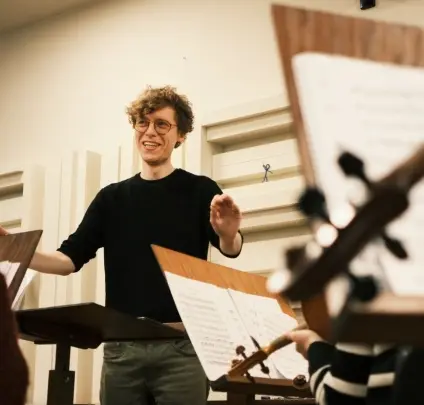 Na zdjęciu widać mężczyzne w sali z instrumentami muzycznymi