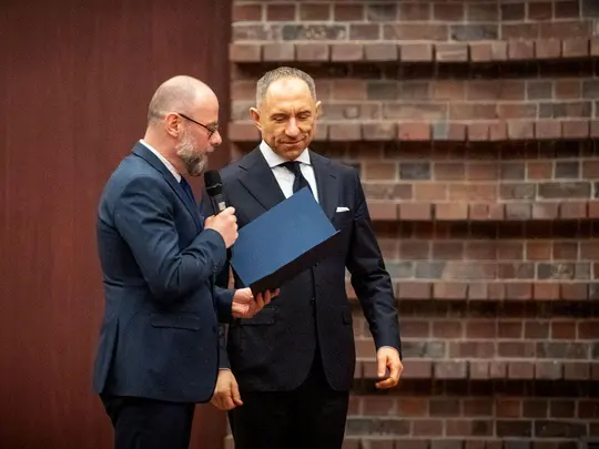 Dr hab. Artur Wr&oacute;bel, prof. AMKL, Przewodniczący Uczelnianej Komisji Wyborczej, wręcza prof. dr. hab. Krystianowi Kiełbowi akt stwierdzający wyb&oacute;r Rektora Akademii Muzycznej im. Karola Lipińskiego we Wrocławiu na kadencję 2024-2028