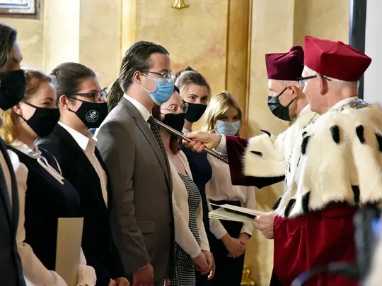 JM Rektor UE prof. dr hab. Andrzej Kaleta wyczytuje nazwiska student&oacute;w, wręcza wydrukowane teksty roty, podczas gdy Przewodniczący KRUWiO prof. dr hab. Krystian Kiełb berłem dokonuje uroczystego aktu pasowania