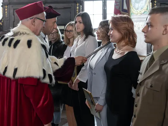 JM Rektor UE prof. dr hab. Andrzej Kaleta wręcza teksty roty, a Przewodniczący KRUWiO prof. dr hab. Krystian Kiełb berłem dokonuje uroczystego aktu pasowania