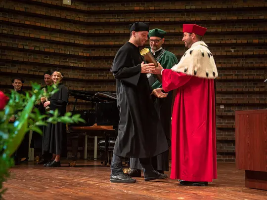 Rektor Akademii Sztuk Pięknych prof. dr hab. Wojciech Pukocz zaprasza na estradę doktor&oacute;w i wręcza dyplomy