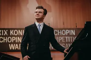 Piotr Alexewicz stoi obok fortepianu po swoim występię podczas Konkursu Chopinowskiego.