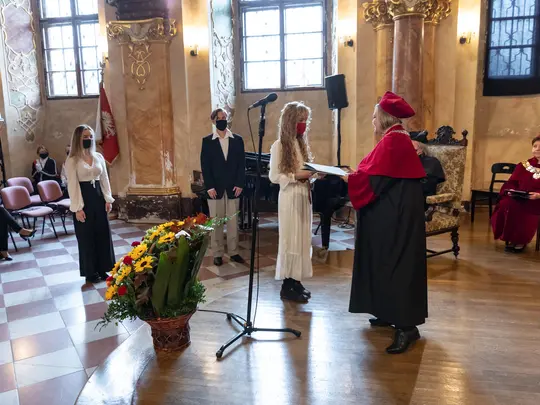 Prorektor ds. dydaktycznych i studenckich Akademii Sztuk Pięknych, dr hab. Beata Mak-Sobota, prof. ASP, wręcza listy gratulacyjne studentom