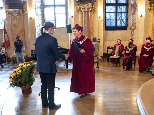 Prorektor ds. studenckich i dydaktyki Akademii Muzycznej, prof. dr hab. Helena Tomaszek-Plewa, wręcza listy gratulacyjne studentom