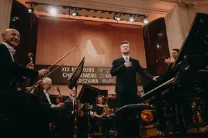 Piotr Alexewicz na estradzie. Uśmiecha się z wdzięcznością.